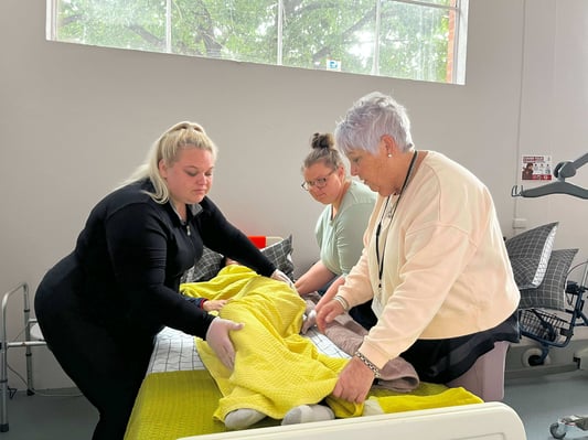 Trainer instructing students on manual handling