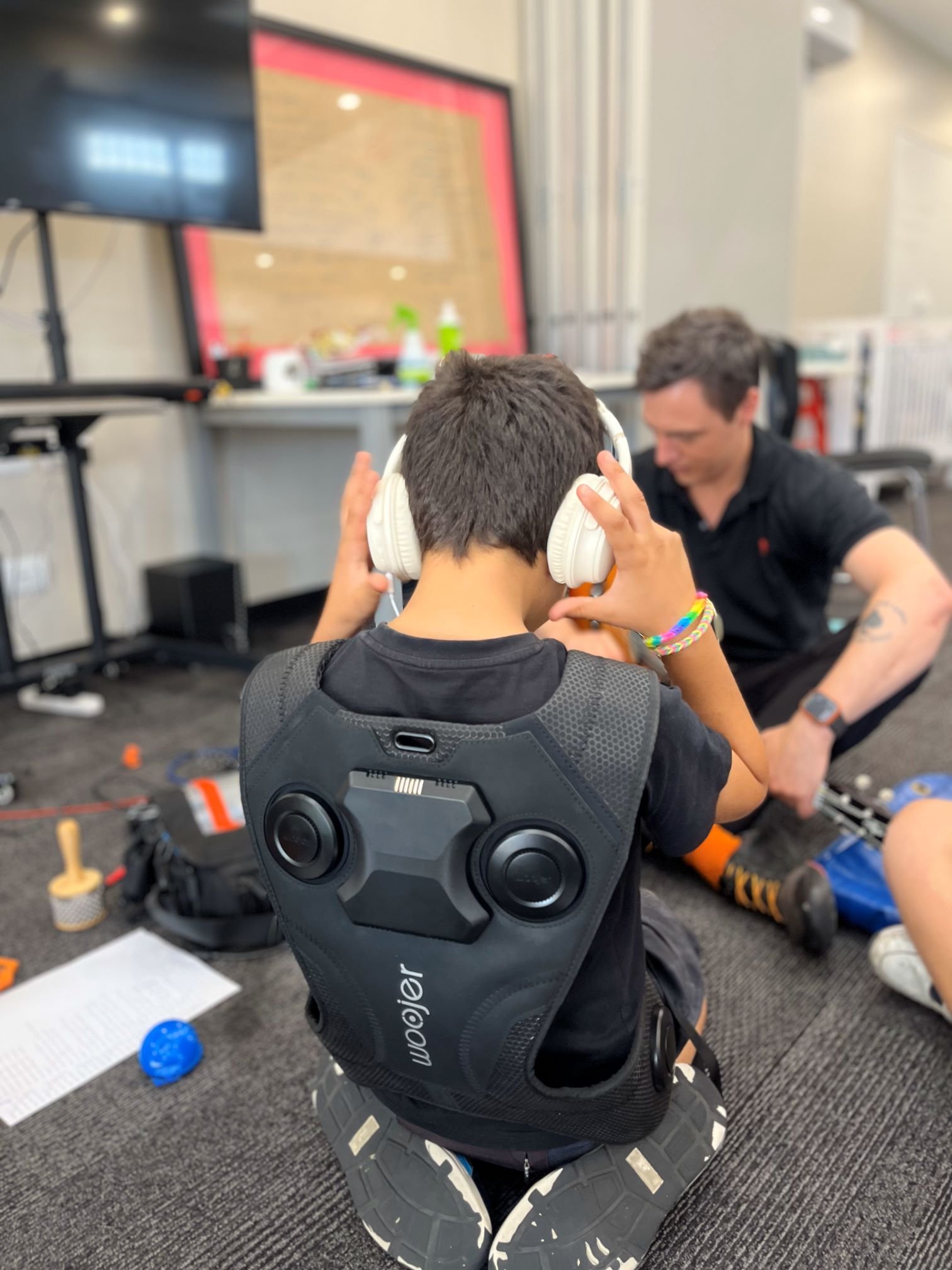 a little boy wearing a haptic vest during a music therapy session