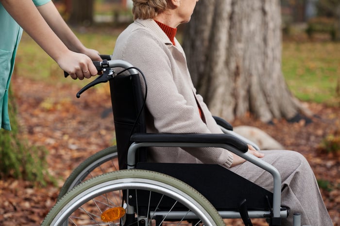 Disabled elder woman on wheelchair with nurse